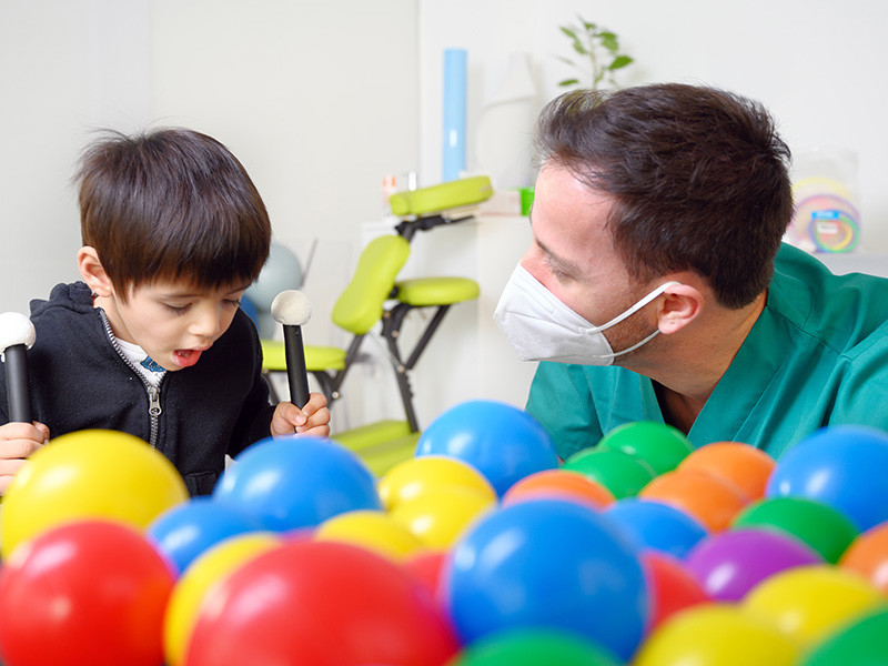Photo of a physiotherapist, Dylan, who is assisting a young boy